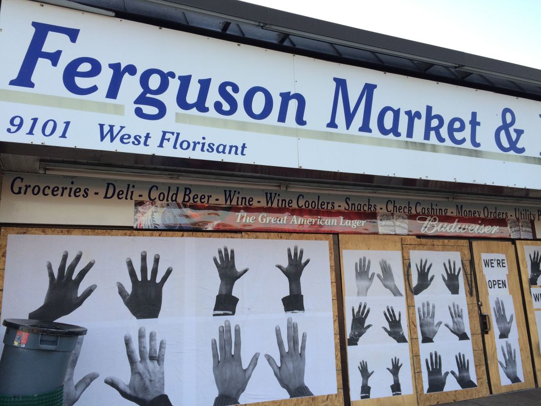 Artist Damon Davis' hands art covers the windows to the convenience store where Michael Brown entered before he was killed August 9.

