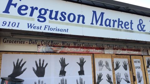 Artist Damon Davis' hands art covers the windows to the convenience store where Michael Brown entered before he was killed August 9.