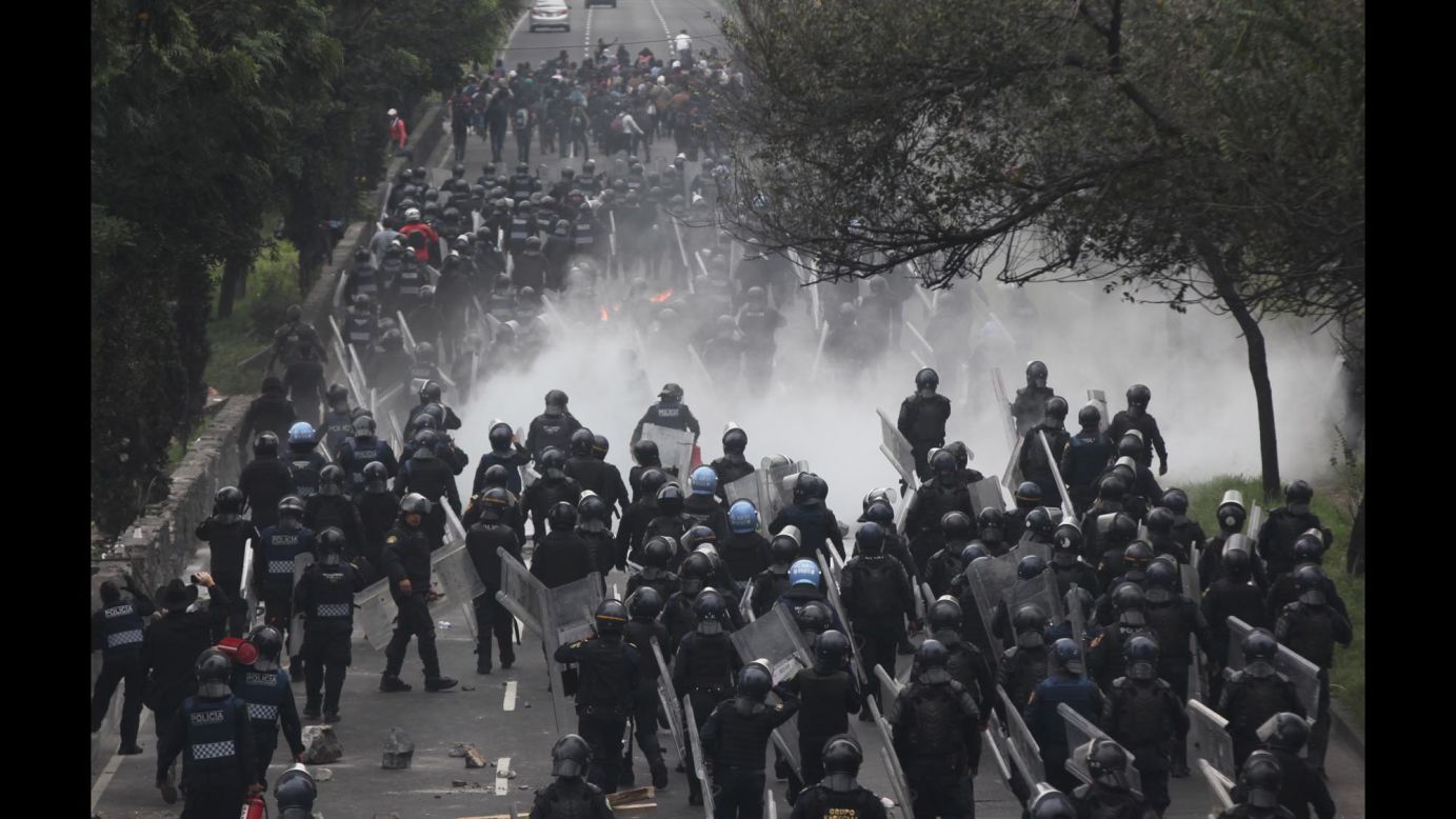 Riot police confront protesters near the airport in Mexico City on Thursday, November 20.