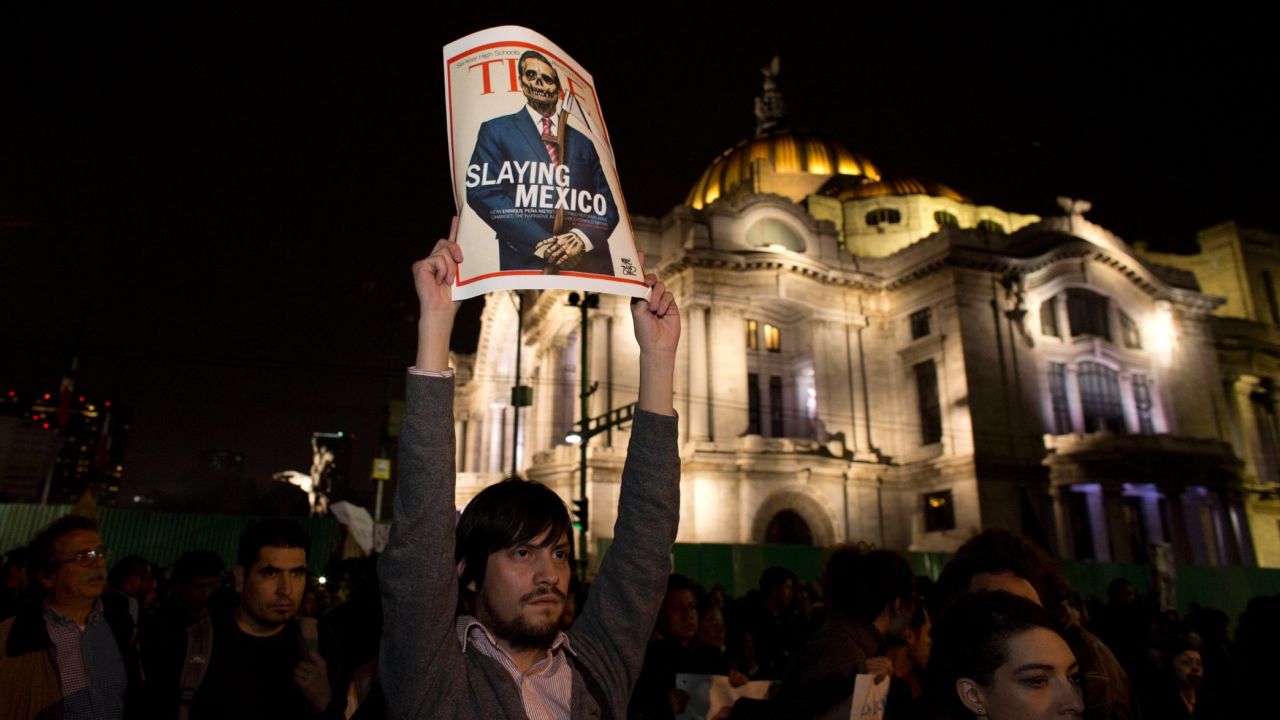 A protester holds up a poster parodying Pena Nieto during a rally in Mexico City on November 20.