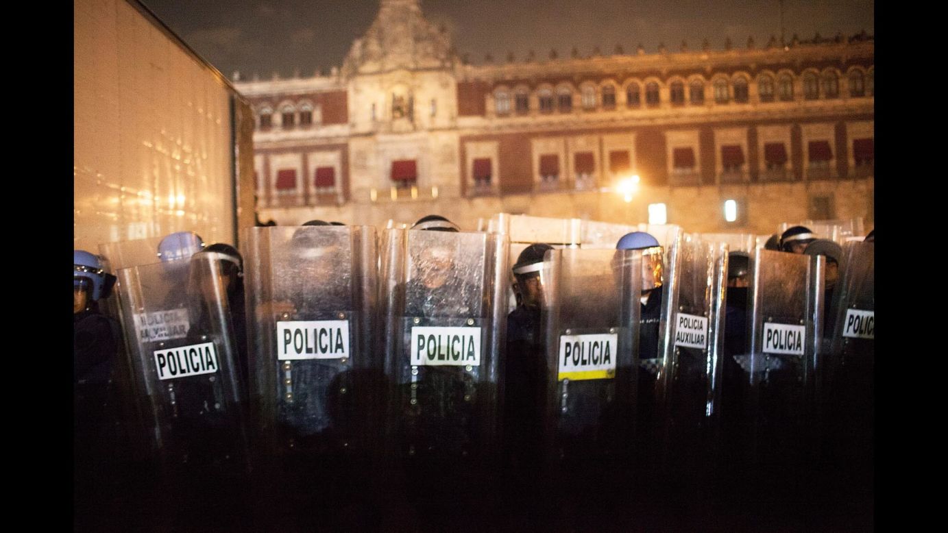 Police guard the National Palace in Mexico City as protesters and police clash on November 20.