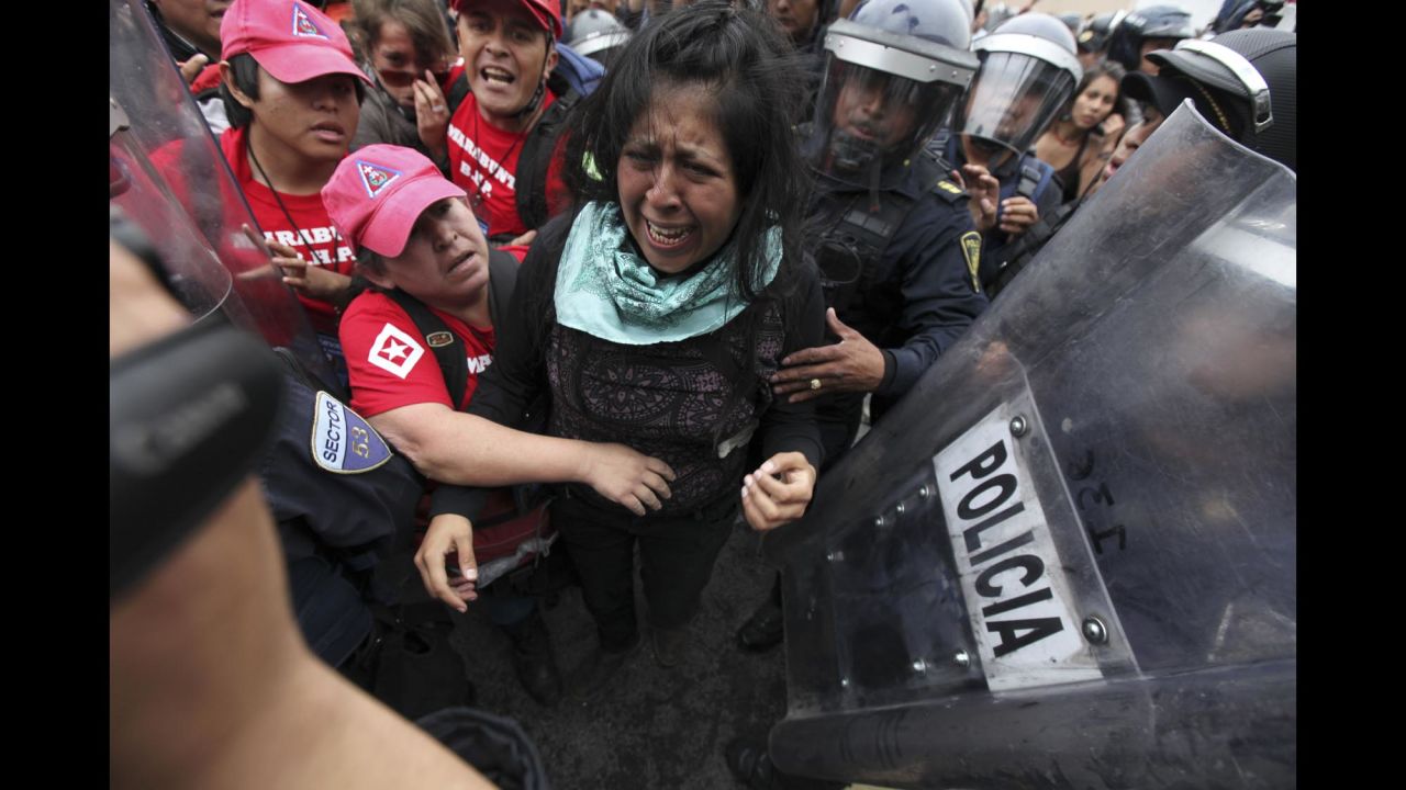 A protester cries as police attempt to detain her and human rights observers try to reach her during a march near the Mexico City airport on November 20.