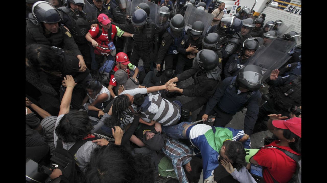 Riot police surround protesters who had thrown Molotov cocktails and destroyed vehicles in Mexico City on November 20.