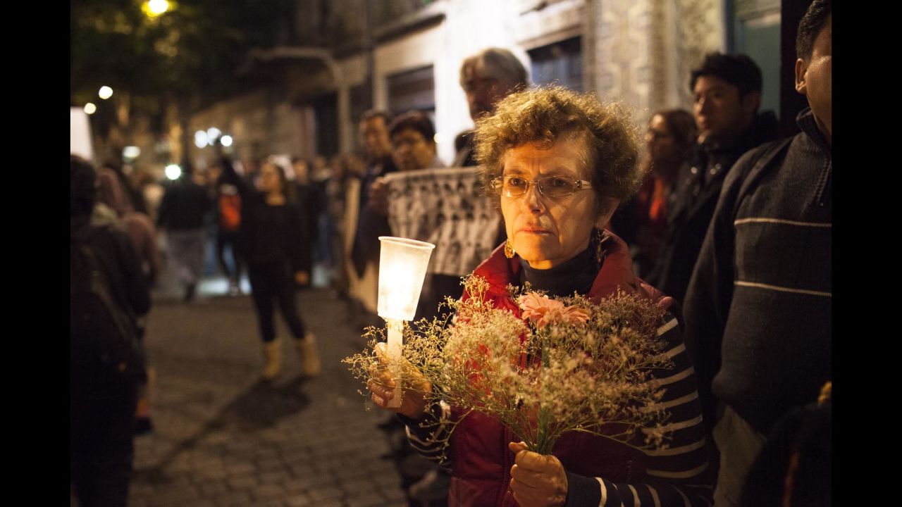 A woman holds flowers and a candle during the November 20 demonstration.