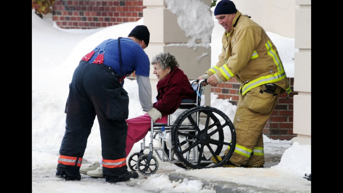Firefighters from Cheektowaga and Depew, New York, assist an elderly patient from from Garden Gate Health Care Facility to the Appletree Mall November 20. About 180 patients from the facility were moved after officials questioned the safety of the roof under the weight of the snowfall.