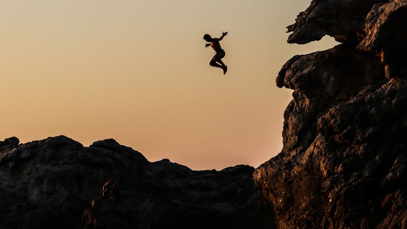 A cliff jumper plunges toward Artimus Cove in Ikaria, Greece.