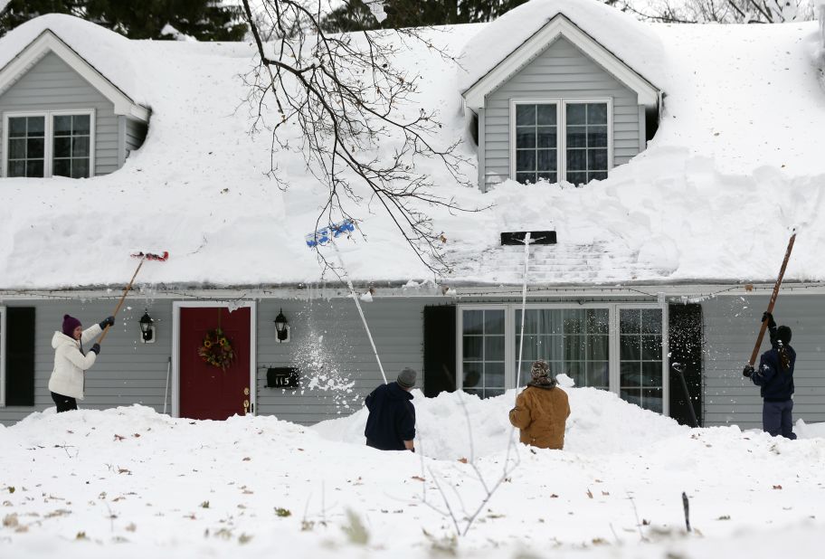 People clear snow from a house on Saturday, November 22 in Orchard Park, New York. 