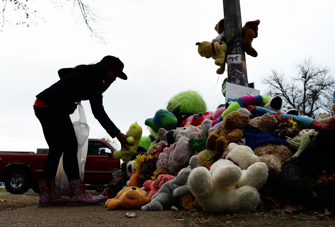 In late November, a wellwisher aranges stuffed toys at a makeshift memorial where 18-year-old Michael Brown was shot dead by a Ferguson police office.