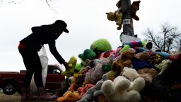 A wellwisher aranges stuffed toys on November 22, 2014 at a makeshift memorial where 18-year-old Michael Brown was shot dead by a police officer, in Ferguson, Missouri. Tensions rose on November 22 in the troubled St Louis suburb of Ferguson, with a grand jury poised to decide whether to prosecute a white police officer for killing an unarmed black teenager. US President Barack Obama has called for calm, Missouri's governor declared a state of emergency and activated the state National Guard, and the FBI has deployed an extra 100 personnel in the city.Police helicopters trained search lights over Ferguson late Friday as a small gaggle of protesters braved the cold to demand that officer Darren Wilson stand trial for shooting 18-year-old Michael Brown on August 9. AFP PHOTO/Jewel Samad (Photo credit should read JEWEL SAMAD/AFP/Getty Images)