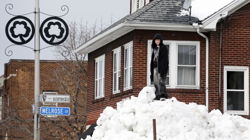 A boy stands on a snowbank in the south Buffalo area on Sunday, Nov. 23, 2014, in Buffalo, N.Y. Western New York continues to dig out from the heavy snow dropped this week by lake-effect snowstorms. (AP Photo/Mike Groll)