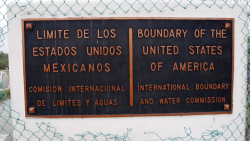 A plaque designates the official border between the United States and Mexico.