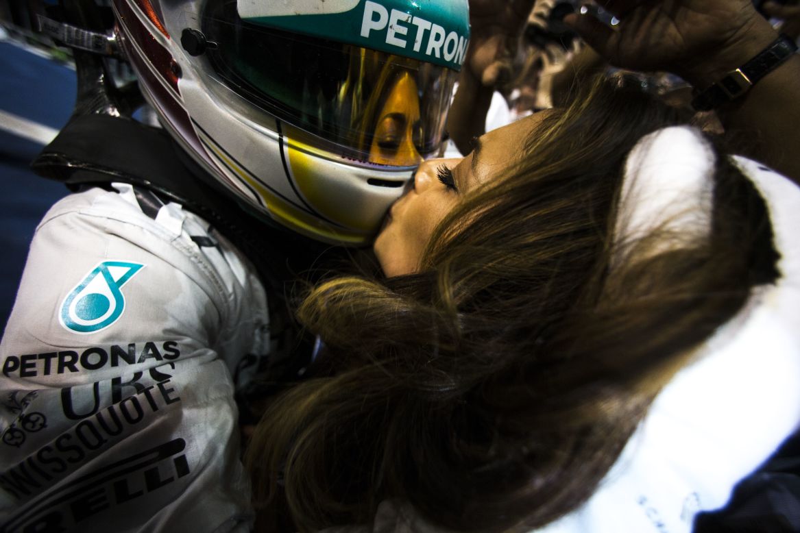 Singer Nicole Scherzinger kisses her boyfriend, Formula One driver Lewis Hamilton, after he clinched the championship Sunday, November 23, in Abu Dhabi, United Arab Emirates. The British driver has now won two F1 titles.