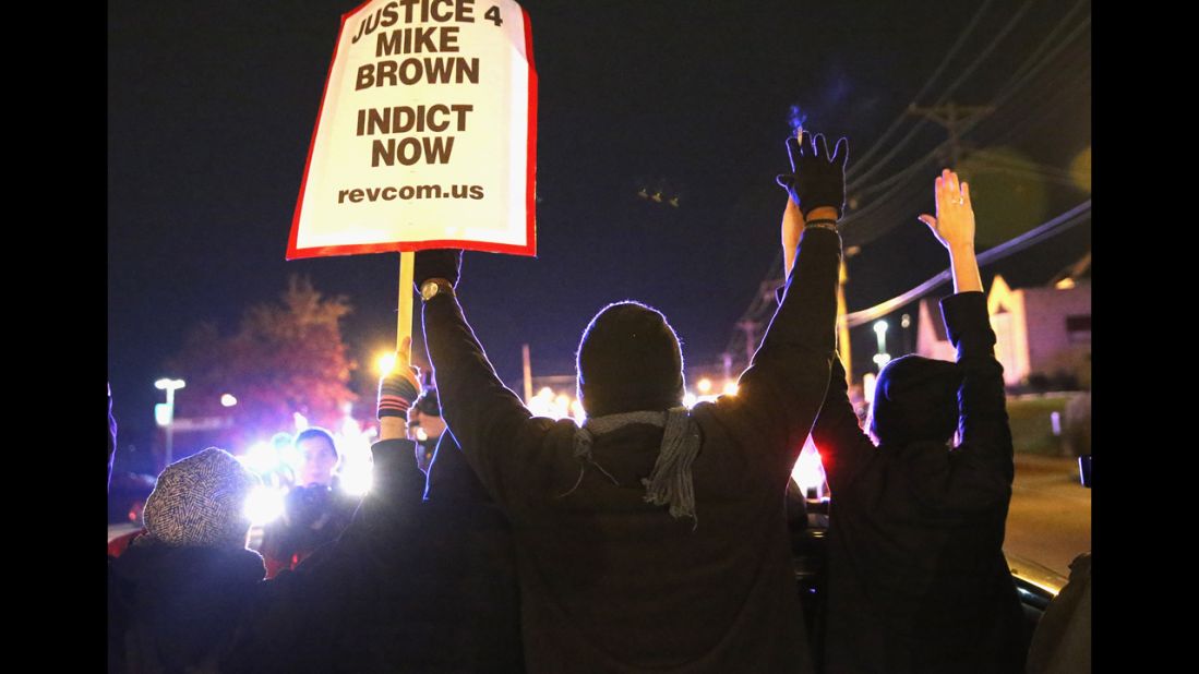 Demonstrators are confronted by police as they block a street before the grand jury announcement. 