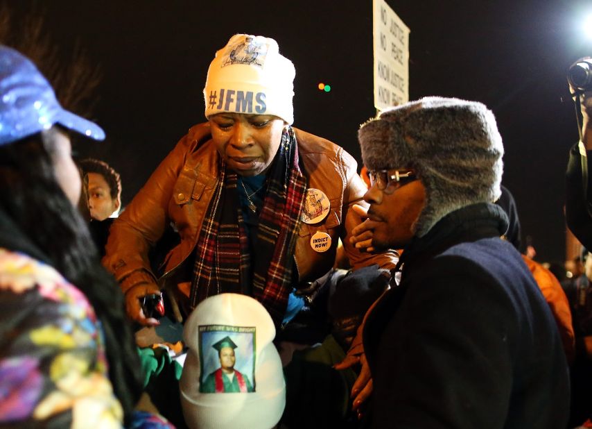 Lesley McSpadden, mother of Michael Brown, is escorted away from the Ferguson Police Department on November 24.