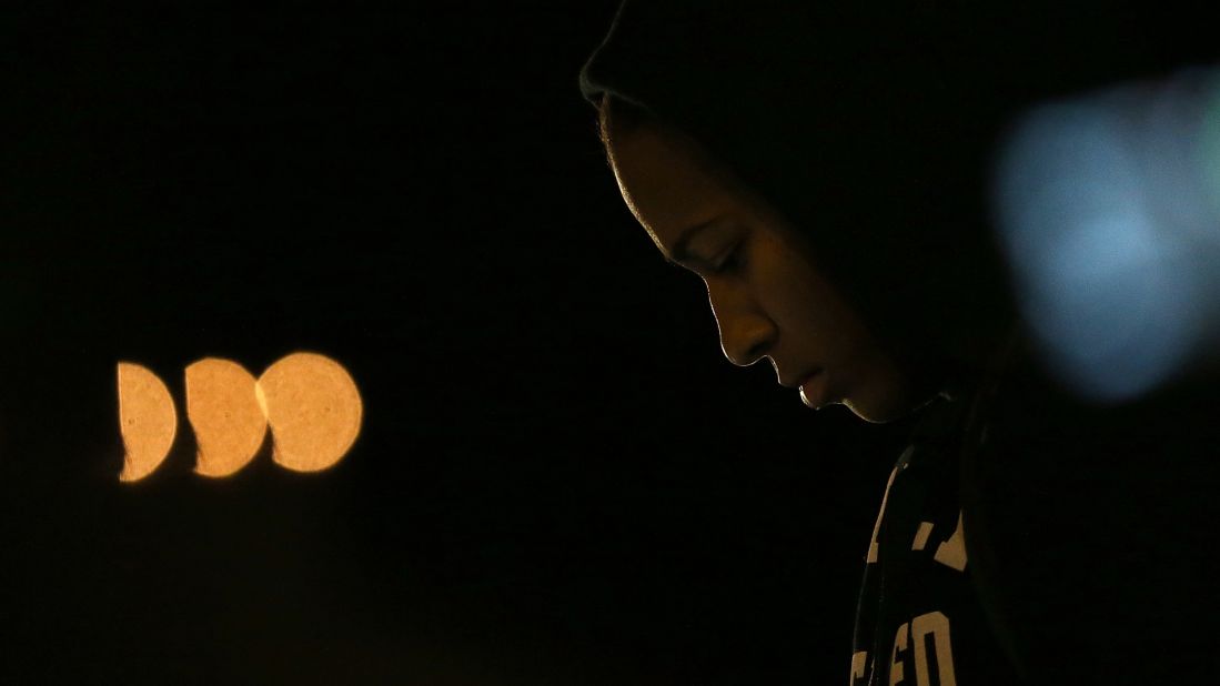 A demonstrator listens to a car radio as the grand jury's decision is delivered in front of the Ferguson Police Department.