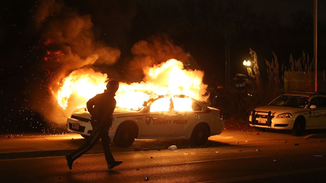 A police officer runs by a burning police car on November 24.