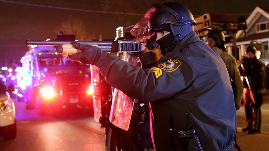 A police officer points his rifle at demonstrators on November 24.