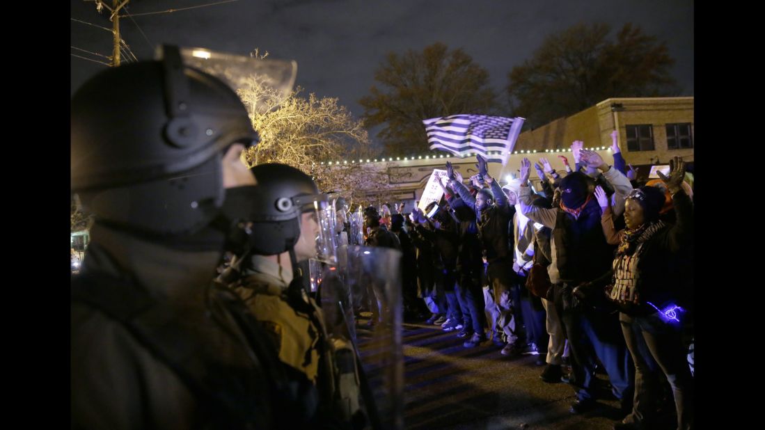 Police officers stand guard as protesters confront them on November 24.