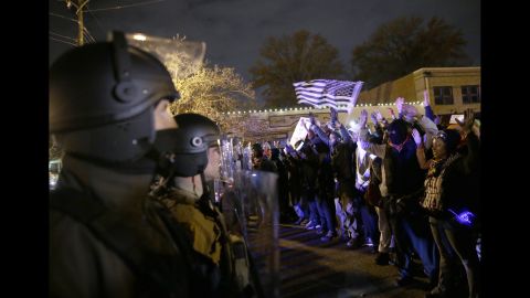 Police officers stand guard as protesters confront them on November 24.