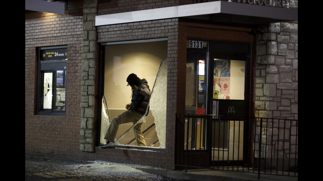 A man steps out of a vandalized store on November 24.