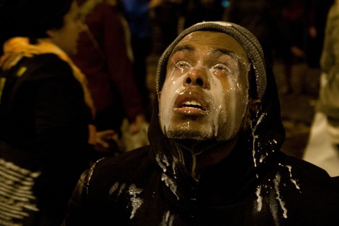 A Seattle protester pours milk in his eyes after being tear-gassed on November 24.