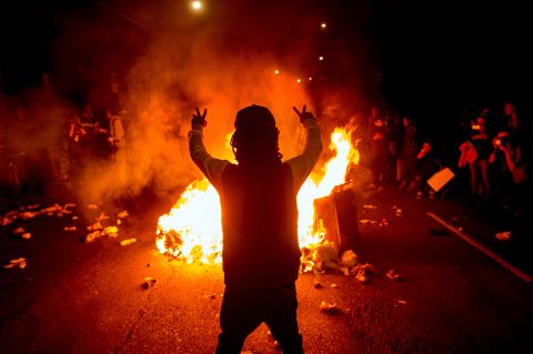 Demonstrators gather around a fire in the streets of Oakland, California, on November 24.