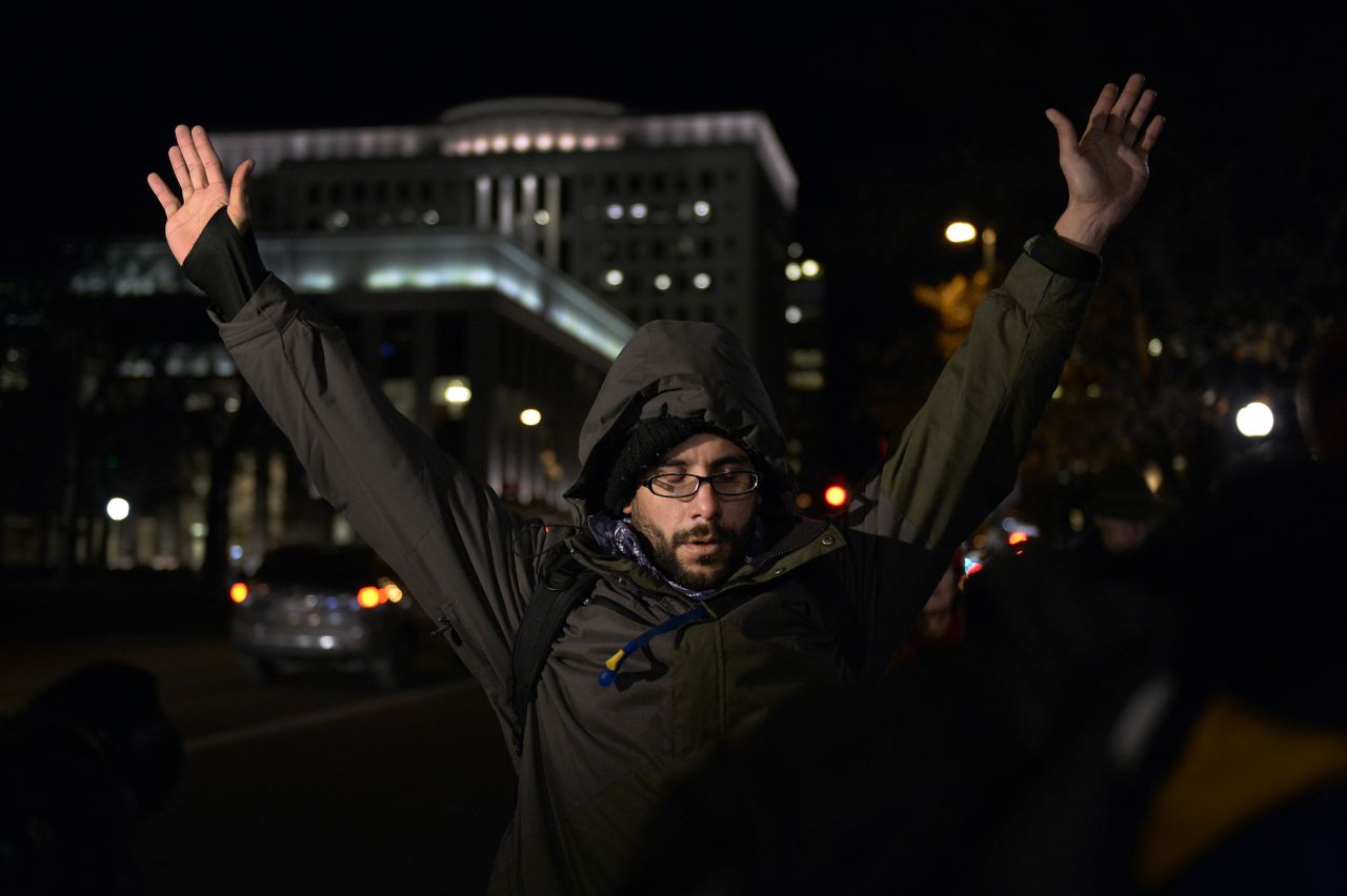 A protester in Denver holds up his arms during a moment of silence November 24 at Civic Center Park.