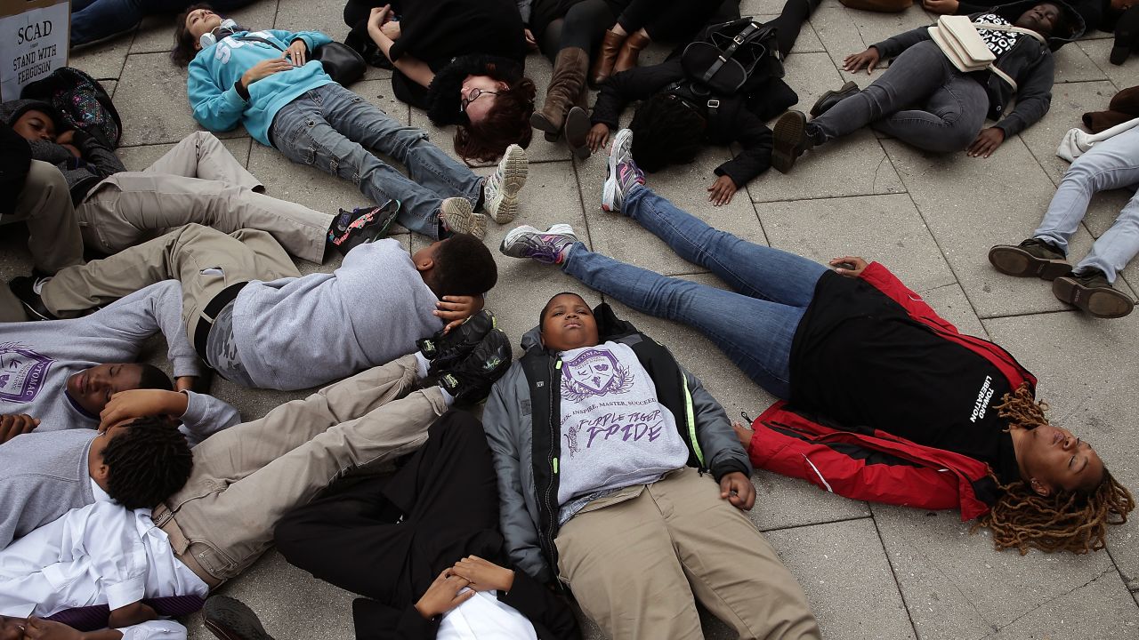 Schoolchildren from the Potomac Preparatory Charter School take part in a "die-in" during a protest outside the Office of Police Complaints as part of a planned "28 Hours for Mike Brown" protest November 25 in Washington. 