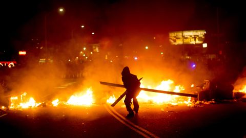 A protester adds wood to a fire burning in Oakland, California, on November 25.