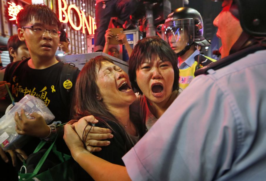 Protesters cry as police officers try to stop them from blocking the road in the Mong Kok district of Hong Kong on Wednesday, November 26. 