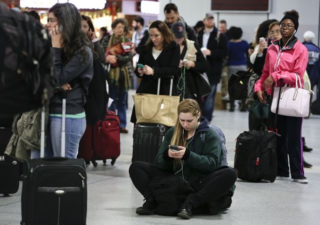 Travelers wait for departure announcements at New York's Penn Station on November 26.