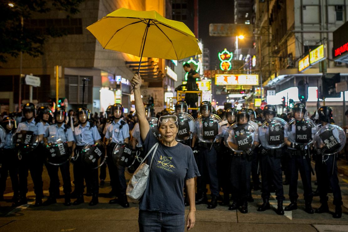 A pro-democracy activist holds a yellow umbrella in front of a police line on November 25, 2014 in Hong Kong. 