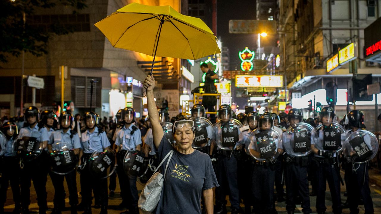 A pro-democracy activist holds a yellow umbrella in front of a police line on November 25, 2014 in Hong Kong. 