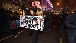 Demonstrators hold up placards and march down Oxford Street in central London on November 26, 2014 during a protest over the US court decision not to charge the policeman who killed unarmed black teenager Michael Brown in the town of Ferguson. The policeman whose killing of unarmed black teenager Michael Brown sparked weeks of riots in the US town of Ferguson will not face charges, the county prosecutor said on November 25, amid mounting anger in the streets. Over a thousand people demonstrated outside the US embassy in London, holding up their hands and waving placards. The demonstration then turned into a march along Oxford Street, one of central London's main retail and shopping streets. AFP PHOTO / LEON NEALLEON NEAL/AFP/Getty Images