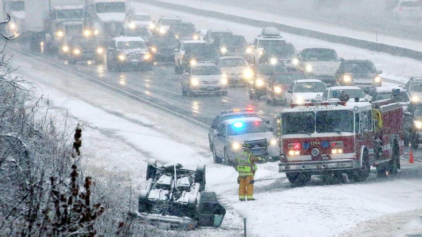 Emergency personnel work at the scene of an overturned vehicle on Interstate 84 in Vernon, Connecticut, on Wednesday, November 26.