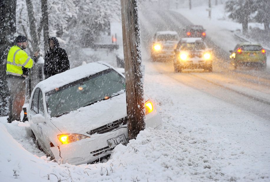 A car sits on the side of the road in Westbrook, Maine, after the driver lost control on Wednesday, November 26. A storm that blew wet snow onto trees and power lines left tens of thousands of Maine residents without power on Thanksgiving. 