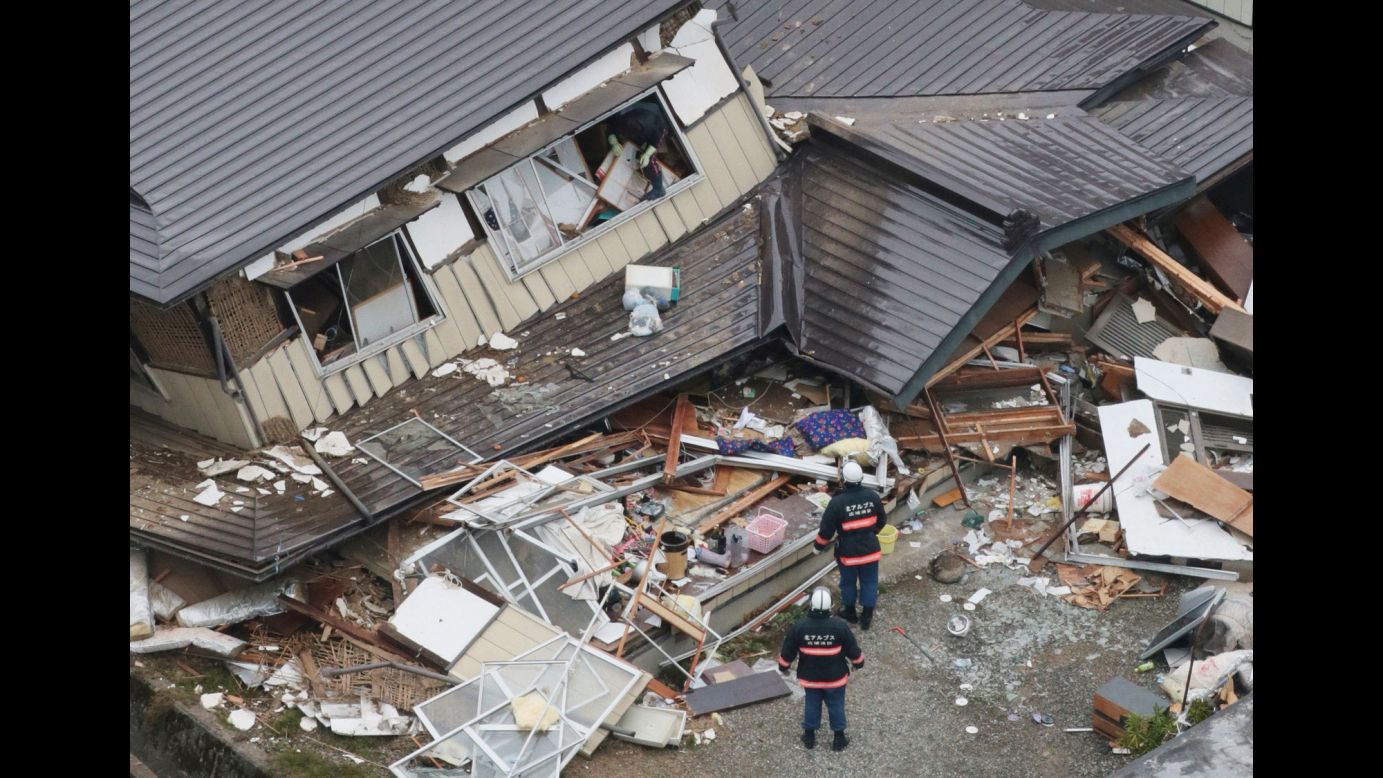 Rescue workers investigate collapsed houses in Hakuba, Japan, after <a href="http://www.cnn.com/2014/11/22/world/asia/japan-earthquake/index.html">an earthquake</a> on Sunday, November 23.