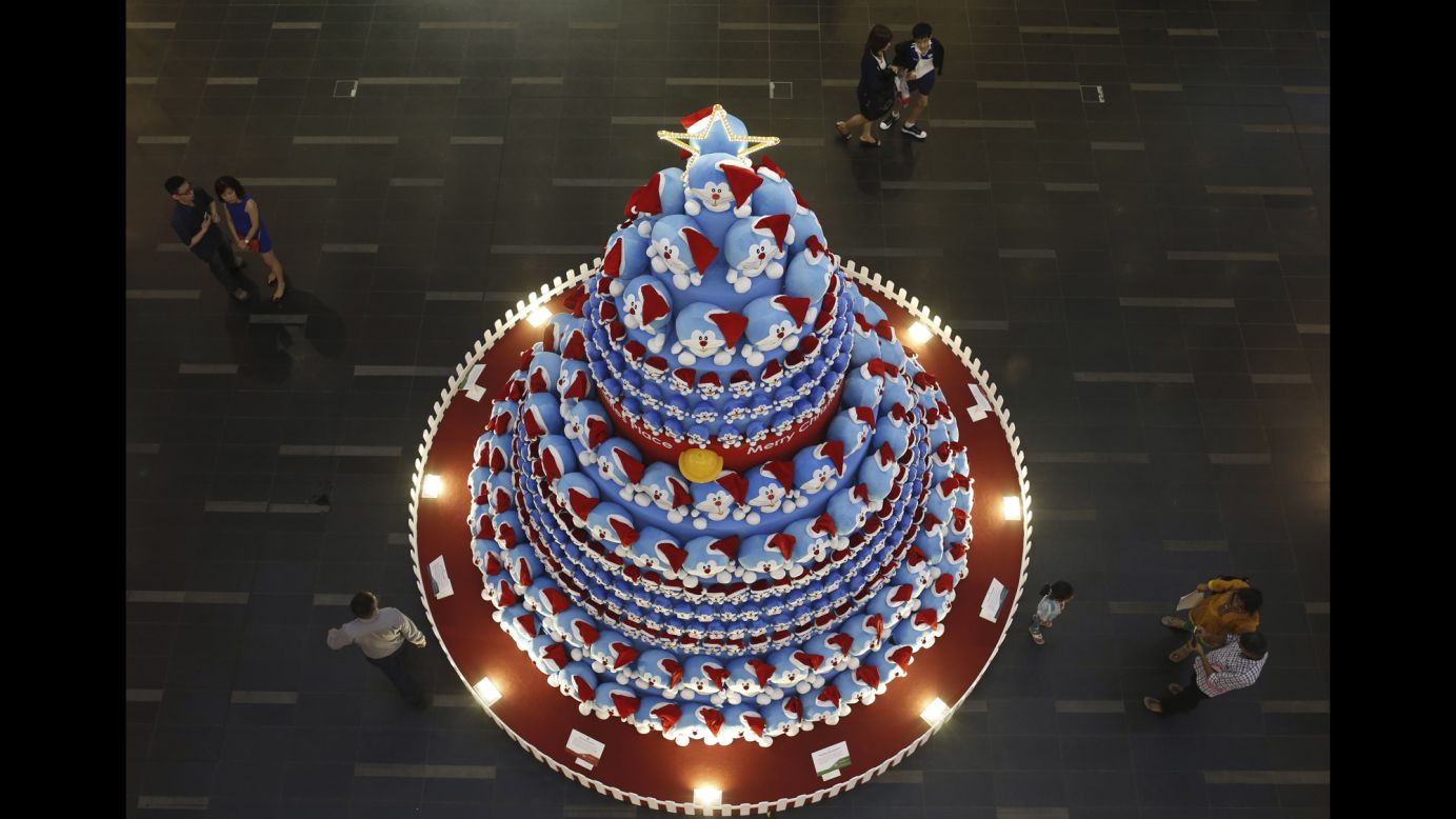 People at a Singapore shopping mall take photos of a Christmas tree made up of Japanese manga character Doraemon on Monday, November 24.