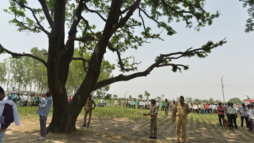 Indian police keep watch at the tree where the bodies of gang rape victims were found hanging, ahead of Congress party Vice President Rahul Gandhi's arrival in Katra Shahadatgunj in Badaun district, India's Uttar Pradesh state, on May 31, 2014. Two minor girls were allegedly gang raped and found dead hanging from the tree. Five men have been arrested over the gang-rape and deaths of two girls found hanging from a mango tree in a northern Indian village, police said May 31. The discovery of the two cousins, aged 14 and 12, in the Budaun district of Uttar Pradesh May 28 is the latest sexual violence case to have stirred national outrage. AFP PHOTO/Chandan KHANNA (Photo credit should read Chandan Khanna/AFP/Getty Images)