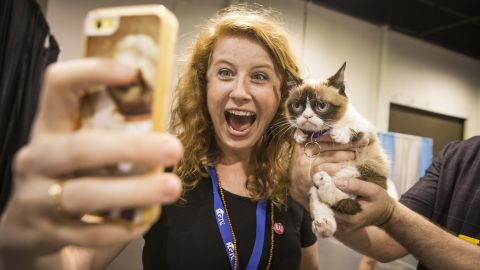 A fan takes a selfie with <a href="http://money.cnn.com/2013/09/18/news/companies/grumpy-cat-friskies/">"Grumpy Cat,"</a> the Internet celebrity famous for her perpetual scowl, on Friday, June 27, at the Anaheim Convention Center in Anaheim, California. The cat, whose real name is Tardar Sauce, is the official "spokescat" for Friskies cat food and <a href="https://www.thefriskies.com" target="_blank" target="_blank">its award show</a> for the best original cat videos.