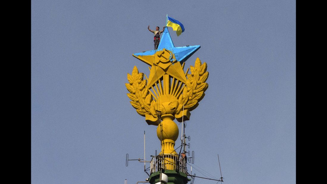 A worker takes a selfie before removing a Ukrainian flag that was attached by protesters atop a Stalin-era skyscraper in Moscow on Wednesday, August 20. Protesters scaled the skyscraper and painted the Soviet star in the national colors of Ukraine. The dangerous prank, which set Russian social networking sites abuzz, drew a harsh response from the police.