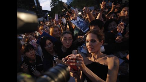 Actress Angelina Jolie tries to take pictures with fans as she attends the Tokyo premiere of her movie "Maleficent" on Monday, June 23. <a href="http://www.cnn.com/2013/05/14/showbiz/gallery/angelina-jolie/index.html" target="_blank">See the life of Angelina Jolie</a>