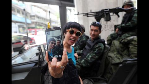 A woman takes a selfie in front of army soldiers standing guard in Bangkok, Thailand, on Tuesday, May 20. A couple of days later, Thailand's military declared it had taken control of the country in a coup.