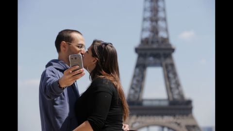 Tourists kiss in front of the Eiffel Tower in Paris on Friday, May 16.