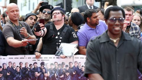 Fans take selfies Monday, August 4, as actor Wesley Snipes, right, arrives for the world premiere of "The Expendables 3" in London.