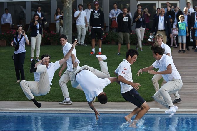 El tenista profesional Kei Nishikori, el segundo desde la derecha, es lanzado al agua luego de ganar la final del Abierto de Barcelona el domingo 27 de abril.