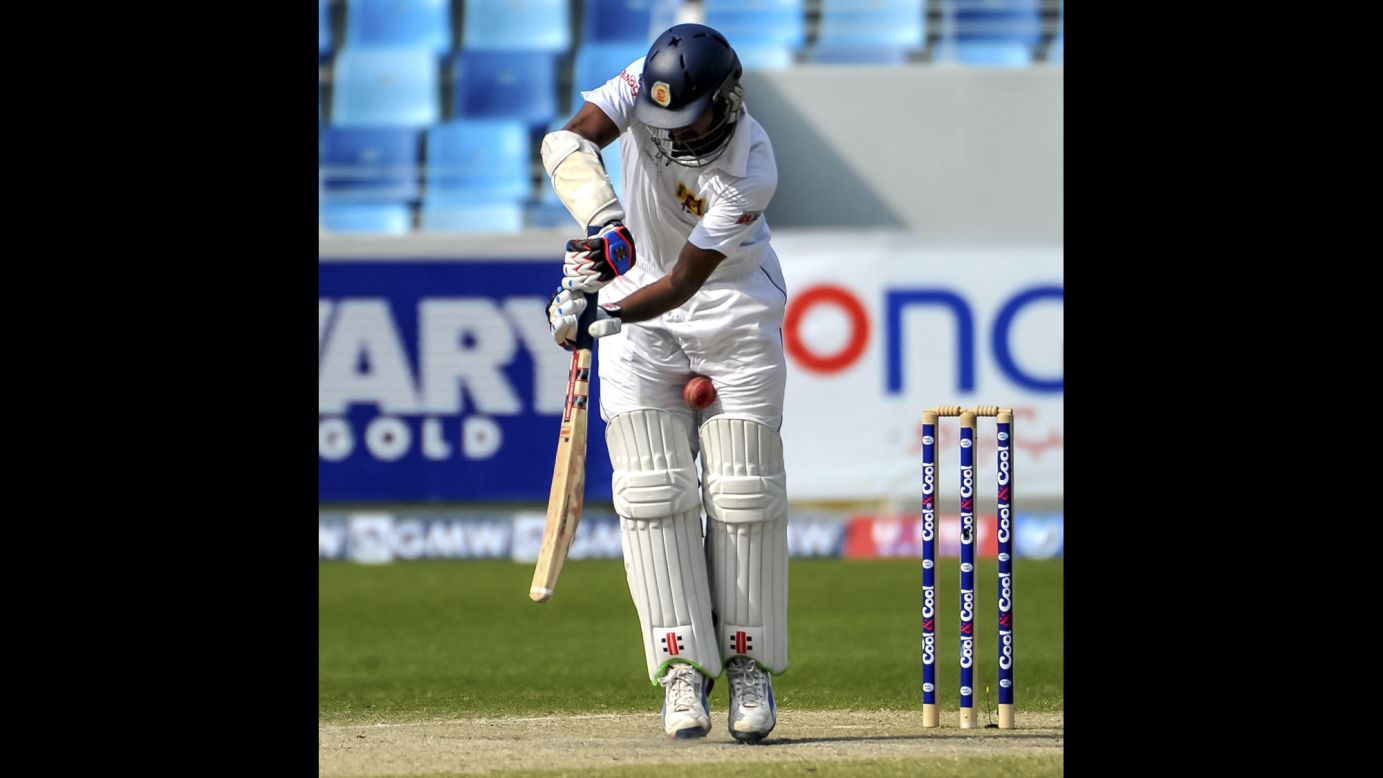 Sri Lankan cricket player Dimuth Karunaratne is hit by a ball Sunday, January 12, during a Test match against Pakistan in Dubai, United Arab Emirates.