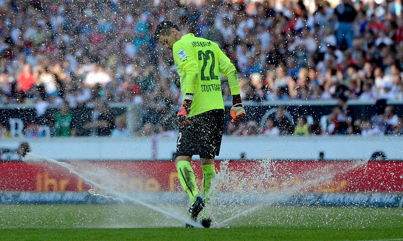 Stuttgart goalkeeper Thorsten Kirschbaum tries to stop a lawn sprinkler during a Bundesliga match Saturday, October 18, in Stuttgart, Germany.