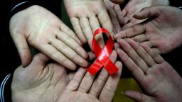 Chinese students show a handmade red ribbon one day ahead of the the World AIDS Day, at a school in Hanshan, east China's Anhui province on November 30, 2009. 