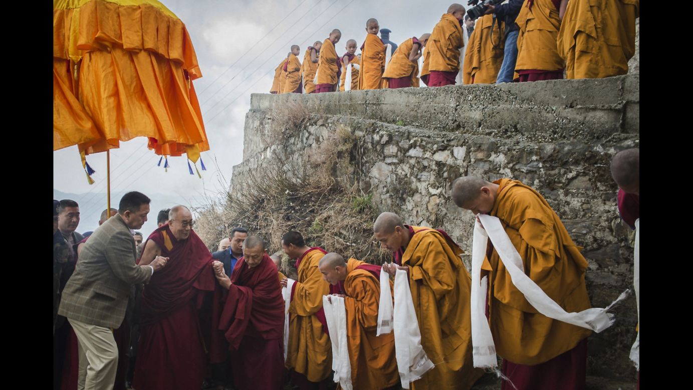 <strong>March 18:</strong> Tibetan Buddhist monks holding ceremonial scarfs stand in line to welcome the Dalai Lama as he arrives at a monastery in Shimla, India.